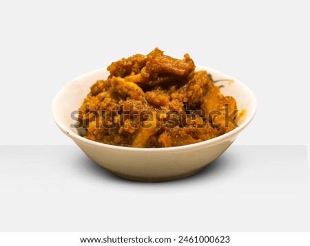Shutki bhuna is served in a white bowl on wooden background. Bengali traditional food dry fish curry. Royalty-Free Stock Photo #2461000623