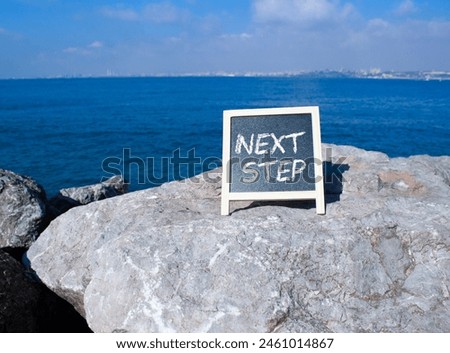 Next Step symbol. Concept words Next Step on black chalk background. Beautiful sea background. Business and Next Step concept. Copy space.