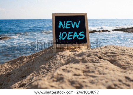 New ideas symbol. Concept word New ideas on black chalk background. Beautiful sea background. Business and New ideas concept. Copy space