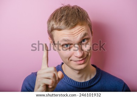 A young man close-up in , consider your index finger. gesture. Photos
