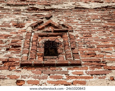 A beautiful loophole in the ancient masonry of the fortress wall Royalty-Free Stock Photo #2461020843