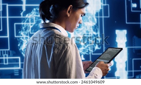 System administrator in data center running programming scripts on tablet, solving tasks. Experienced programmer manipulating lines of code for artificial intelligence applications development Royalty-Free Stock Photo #2461049609