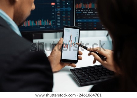 Focusing on phone with discussing dynamic stock market in two business traders online website compare with pc screens in real time currency rate investment on risk data at modern office. Postulate. Royalty-Free Stock Photo #2461064781
