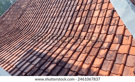 view of clay roof tiles coated with aluminum zinc on top of the house with a slanted front view as a background Royalty-Free Stock Photo #2461067837