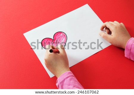 Young Girl Hand with Marker Draws Red Heart.