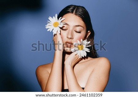 Fresh Blooming Beauty: Young Woman with Flowers in Her Hair, Posing in a Green Field - Closeup Portrait of a Pretty Caucasian Model in Spring.