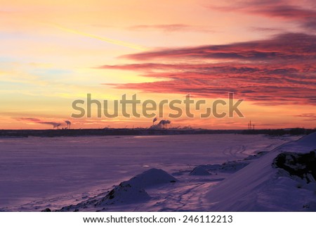 winter landscape beautiful sunset over the river covered with ice and the city on the horizon 