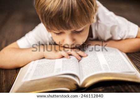 little boy studying the scriptures.