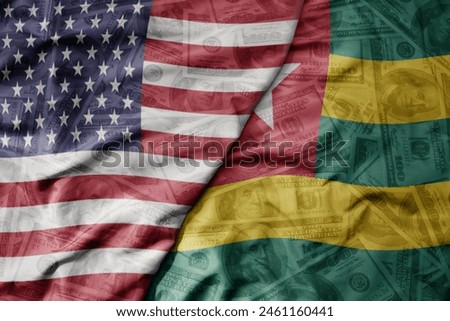 big waving colorful flag of united states of america and national flag of togo on the dollar money background. finance concept . macro