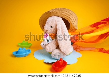 A rabbit toy rides on an inflatable circle on a yellow background
