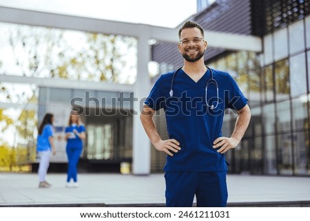 Medical professional working in a hospital. He is dressed in scrubs looking at the camera smiling with a stethoscope around his neck. Young male nurse home caregiver 