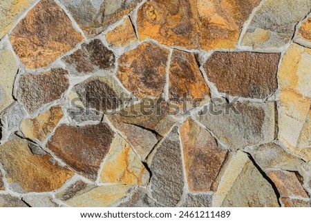 It is the close up view of multicolored stone wall.  It's photo of mosaic stones in wall. This is colorful texture for designer. 