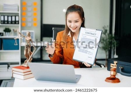 Asian lawyer woman working with a laptop and tablet in a law office. Legal and legal service concept. Looking at camera