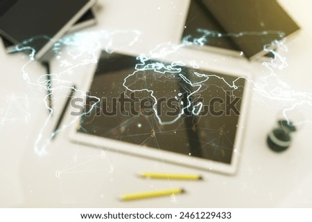 Multi exposure of abstract graphic world map and modern digital tablet on desktop on background, top view, big data and networking concept