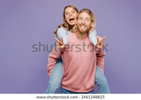 Young couple two friends family man woman wears pink blue casual clothes together giving piggyback ride to joyful, sit on back show v-sign isolated on pastel plain purple background studio portrait Royalty-Free Stock Photo #2461248825