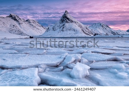 Snow covered steep mountain with frozen river on Lofoten Islands, Arctic, Norway, Europe