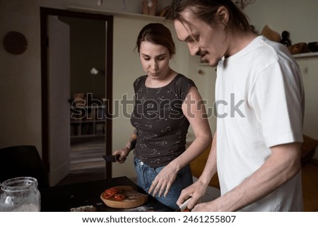 woman and man making pizza in kitchen at home together. Low shooting point, lifestyle, selective focus