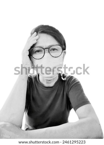 Black and white picture of 50 Asian 50years old woman wearing a mask to protect against dust pm2.5 or covid19 is holding her head because she has a headache.