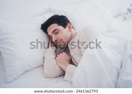 Photo of nice attractive man enjoying peaceful calm sleeping in soft cosy bed white room interior inside