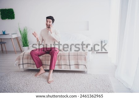 Photo of attractive glad man speaking phone listening news weekend morning cozy apartment white day light indoors Royalty-Free Stock Photo #2461362965