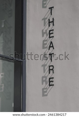 Close up of aluminum sign letters pinned to a building wall