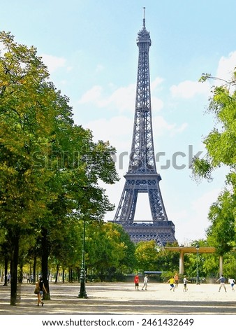A Group of Children Playing Football in Front of Eiffel Tower.