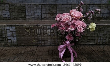 Pink bouquet in a vase. Bright flowers with a dark atmosphere. Flowers in gloomy day. Flowers of mourning. For Background or Wallpaper. Dark femininity concept.