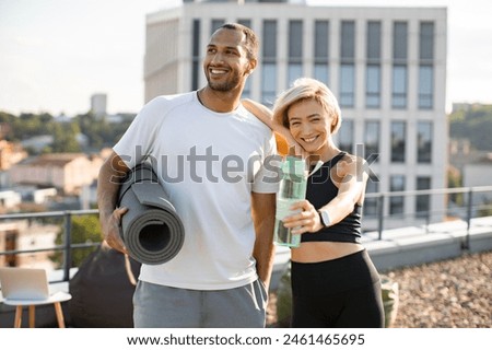 Young woman in black sportswear and man in white t-shirt have healthy lifestyle. Happy family husband and wife rest after running in summer morning on background of city.
