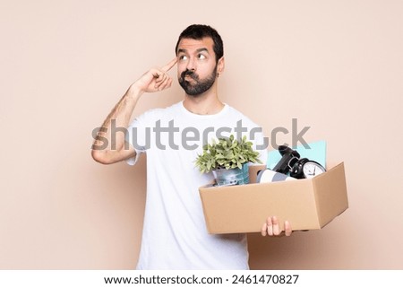 Man holding a box and moving in new home over isolated background having doubts and thinking
