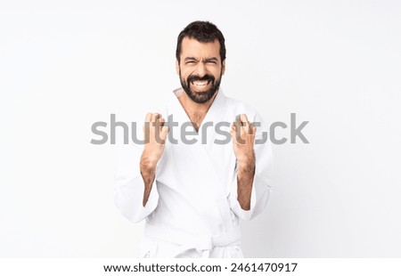 Young man doing karate over isolated white background frustrated by a bad situation