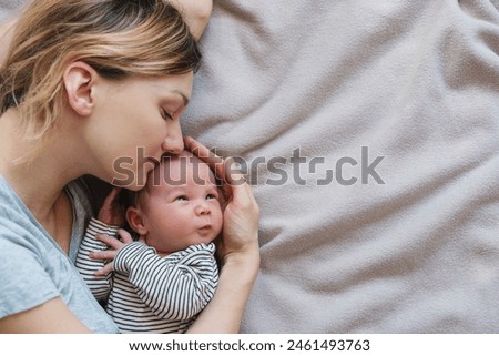 Mother and baby. Loving mom spending time with her little 2 weeks old child at home. Image of bonding mother and baby, healthy physical and mental development of child, happy maternity and family.