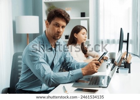 Office worker smart man using tablet and pen to search looking at camera photo shooting portrait business using pen to pose profile with beautiful coworker at modern office at morning time. Postulate.