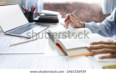 Businessman, lawyer, legal advisor, working with laptop and reading legal processing books for accuracy in contract documents reviewing business contracts before giving advice to customers