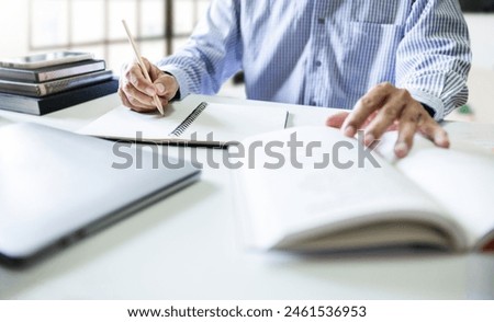 Businessman, advisor or lawyer taking a note and working with laptop reading legal processing books at office before giving advice to clients regarding business law or insurance