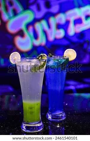 The drinks in the image are unlikely to be mojitos. Mojitos are traditionally a light, refreshing drink with a greenish-tinted hue, due to the mint. The drinks pictured appear to be blue and green, wh