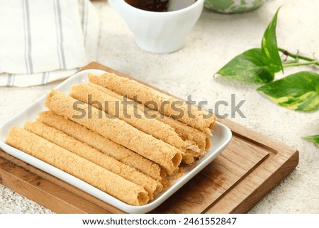 Egg Roll Biscuit or Kue Semprong or sapit, Simping, kue Belanda, or kapit or Love letters in English. It is an Indonesian traditional wafer snack or kuih. Royalty-Free Stock Photo #2461552847