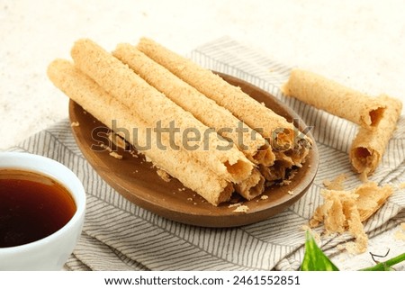 Egg Roll Biscuit or Kue Semprong or sapit, Simping, kue Belanda, or kapit or Love letters in English. It is an Indonesian traditional wafer snack or kuih. Royalty-Free Stock Photo #2461552851