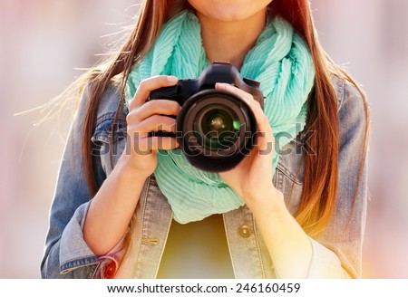 Young photographer taking photos outdoors Royalty-Free Stock Photo #246160459