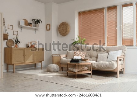 Interior of living room with sofa, drawers and vintage typewriter on table