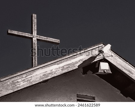 A lithograph filter on a DSLR photograph of a wood crucifix and a security camera on a roof top.
