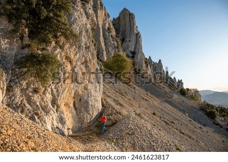 Woman backpacker on the hiking path to Frares de Serrella mountain range on Costa Blanca, Quatretondeta , Alicante, Spain - stock photo
