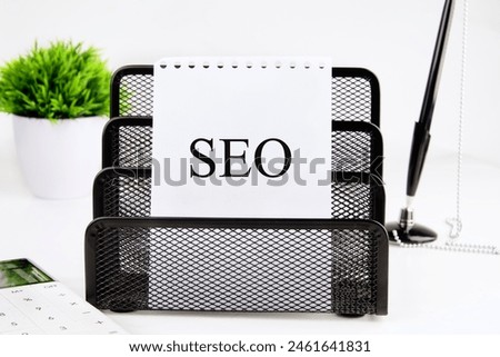 SEO business, SEO concept. Search engine optimization text on a blank sheet in a black stand on a white background