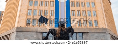The female student who graduated from the university with her back to the university with her arms raised, stock photo