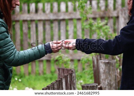 a woman passes a mint leaf to another woman