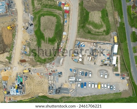 Drone top down view of a English housing development site, showing a large parking area for contractors of the site.