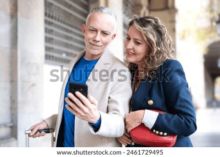 Happy friends or couples using an app on the smartphone outdoors.
