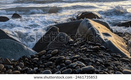 The cool Melted Rocks of Swamis Beach. Erosion control boulders placed along the shore 50 years ago surrounded by ancient river rocks all in the surf mix at Swamis Reef Surf Park Encinitas California.