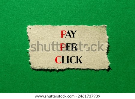 Pay per click words written on ripped paper with green background. Conceptual PPC pay per click symbol. Copy space.