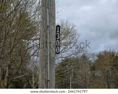 A civic sign for 1300 attached to a pole.
