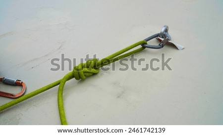 green rope with carabiner at anchor point.rope access